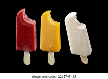 Variety of delicious cold summer fruit popsicles isolated on a black background