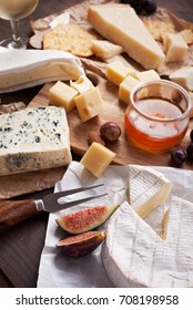 Variety of different cheese with wine, fruits and nuts. Camembert, goat cheese, roquefort, gorgonzolla, gauda, parmesan, emmental - Shutterstock ID 708198958