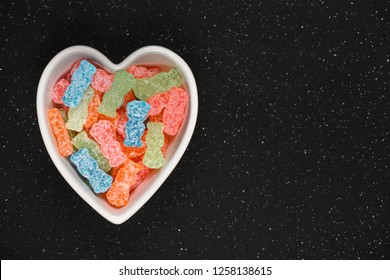 Variety Of Different Color Sweet And Sour Candy Or Sugar Junk Food In A Heart Shaped Bowl.