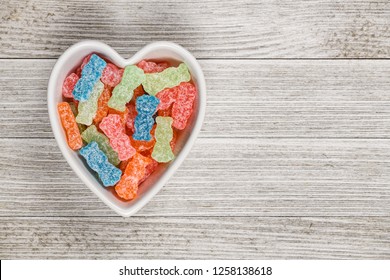 Variety Of Different Color Sweet And Sour Candy Or Sugar Junk Food In A Heart Shaped Bowl.