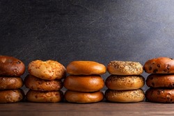 Variety Of Different Flavored Bagels On A Dark Wood Table