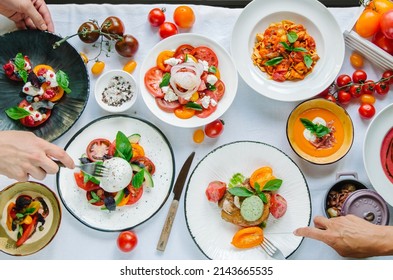 Variety of dishes on the table. Tomato menu in the restaurant, tomato soup, mix of tomatoes with buffalo mozzarella and pesto, pork fillet with baked tomatoes, pasta with tomato sauce, tomato salad. 