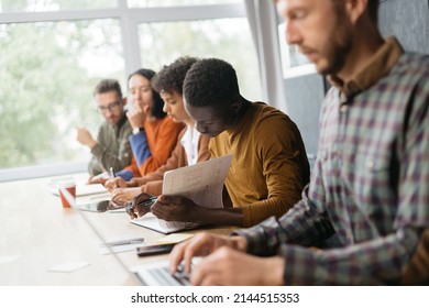 variety of employees sitting at a desk in a coworking center. - Shutterstock ID 2144515353