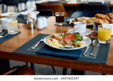Variety of food and drinks served at dining table during breakfast at hotel restaurant.