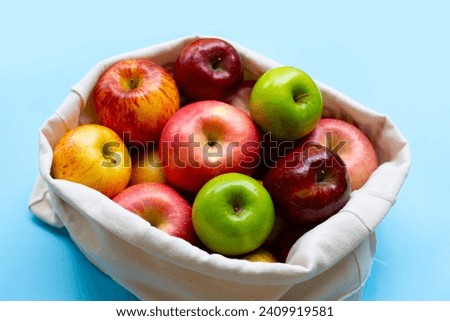 Variety of fresh apples on blue background.