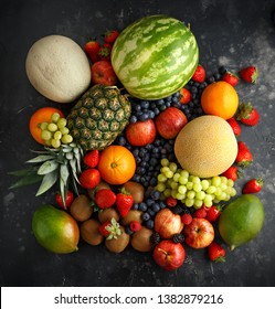 Variety Of Fresh Fruits And Berries On Dark Background: Cantaloupe, Melon, Watermelon, Blueberry, Oranges, Apple, Strawberry, Pineapple, Mango, Grapes And Kiwi.