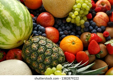 Variety Of Fresh Fruits And Berries On Dark Background: Cantaloupe, Melon, Watermelon, Blueberry, Oranges, Apple, Strawberry, Pineapple, Mango, Grapes And Kiwi.