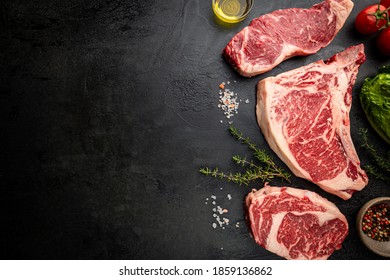 Variety of Fresh Raw Black Angus Prime Meat Steaks T-bone, New York, Ribeye and seasoning on black background, top view - Shutterstock ID 1859136862