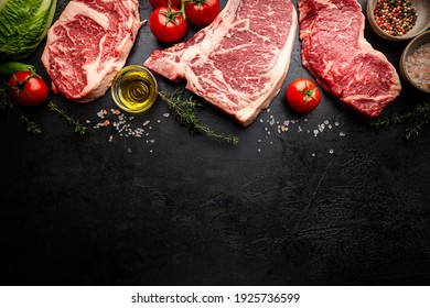 Variety of Fresh Raw Black Angus Prime Meat Steaks T-bone, New York, Ribeye and seasoning on black background, top view - Shutterstock ID 1925736599