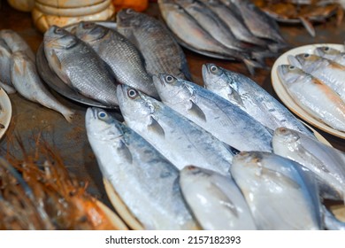 Variety of freshly caught sea fishes, namely sardines, rohu, barramundi, flathead grey mullet etc., ready to deep fried in oil after dipping in spicy batter. Shot taken at a fish stall in Puri beach.