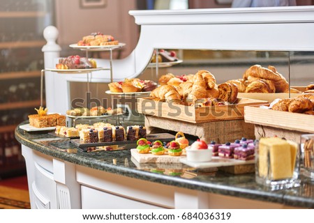 A variety of freshly made pastry in the sunlight, luxury hotel breakfast buffet isolated, restaurant interior