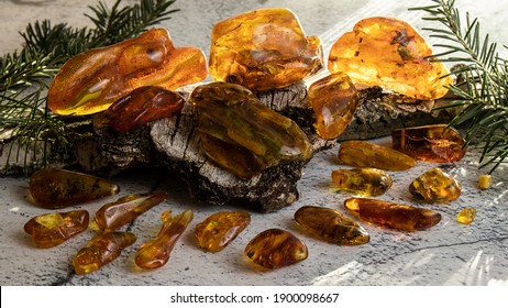 Variety Of Glittering Old Baltic Amber Stones Are Beautifully Laid Out On A Birch Bark.  Amber Texture, Material For Jewelers. Ancient Amber Is Healing, Powers, Protection, Strength, Love And Luck. 