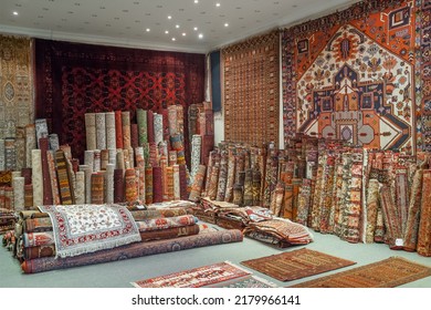 Variety of the gorgeous oriental carpets in traditional carpet store in Middle East. Pile of beautiful handmade carpets on the traditional Middle East market bazaar. 