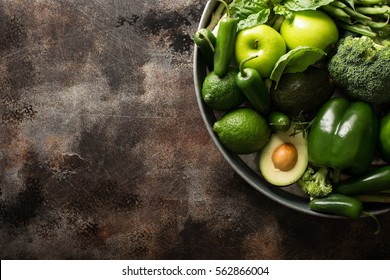 Variety Of Green Vegetables And Fruits On A Tray, Dark Setting Overhead Shot