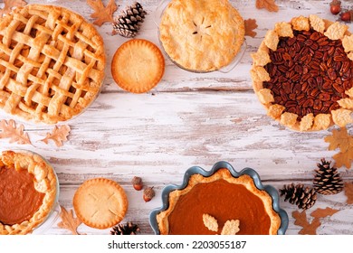 Variety Of Homemade Fall Pies. Pumpkin, Apple And Pecan. Top Down View Frame On A White Wood Background With Copy Space.