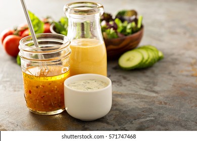 Variety of homemade sauces and salad dressings in jars including vinaigrette, ranch and honey mustard