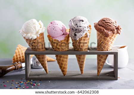 Variety of ice cream scoops in cones with chocolate, vanilla and strawberry