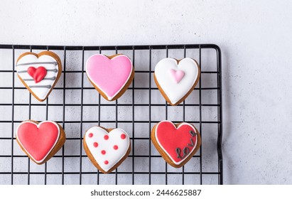 Variety of icing covered biscuits. Heart shaped cookies on cooling rack, overhead shot. - Powered by Shutterstock