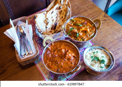 A variety of Indian food with rice in oriental bowls. Rice, soy cheese with vegetables in curry sauce and traditional Indian flat cake