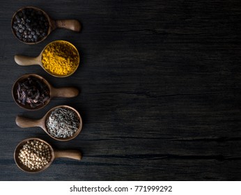 The Variety Of Indian Spices In Wooden Short Spoon On Wooden Texture Table, Flatlay In Dark Tone And Selective Light Spot