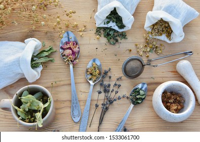 Variety Of Medical Dried Herbs In Spoons And Linen Bags For Herbal Medicine And Home Apothecary, Rustic Style Flat Lay.