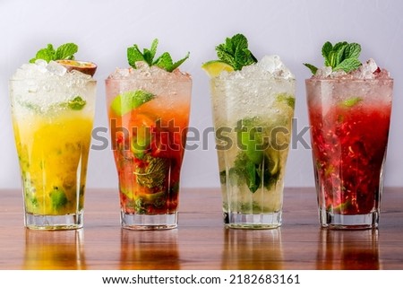 A variety of mojitos in a row on wooden table