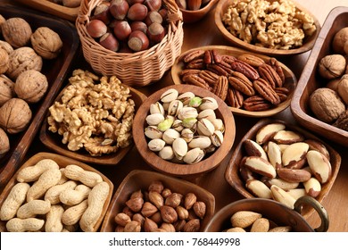 A variety of nuts in wooden bowls. - Shutterstock ID 768449998