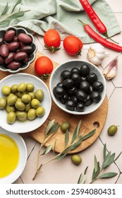 Variedad de aceitunas, tomates, ajo, chiles y aceite de oliva dispuestos en la mesa de la cocina, creando un ambiente culinario acogedor
