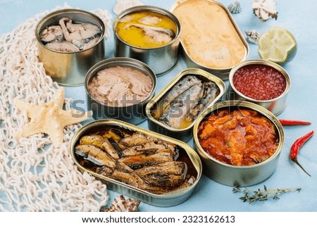Variety of opened tins with different types of canned fish and seafood. Natural source of omega 3 and vitamin d