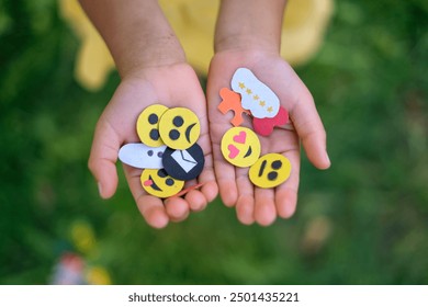 A variety of paper emojis and a set of icons in the hands of a child - Powered by Shutterstock