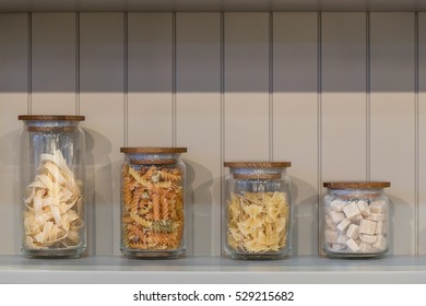 variety of pasta in glass jar on wooden cupboard