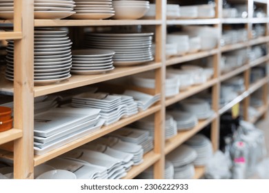 Variety of plates displayed on shelving in household goods store. Kitchen utensils and dishware for sale - Shutterstock ID 2306222933