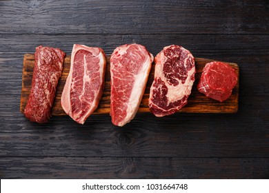 Разнообразие сырья черный Angus Prime мясо стейков Machete, лезвие на кости, Стриплов, Реберный глаз, вырезка филе миньон на деревянной доске копирования пространства