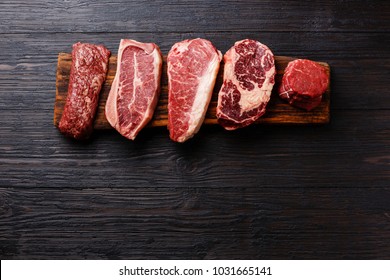 Variety of Raw Black Angus Prime meat steaks Machete, Blade on bone, Striploin, Rib eye, Tenderloin fillet mignon on wooden board copy space - Shutterstock ID 1031665141