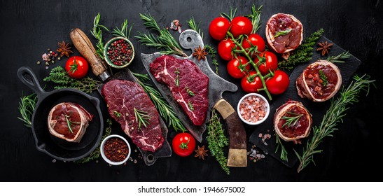 Variety Of Raw Black Angus Prime Meat Steaks Beef Rump Steak, Tenderloin Fillet Mignon Or Grilling With Seasoning On Black Background. Banner, Menu Recipe Top View.