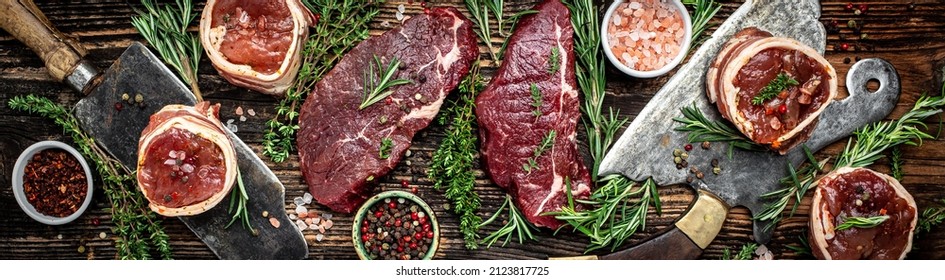 Variety of raw black angus prime meat steaks beef rump steak, Tenderloin fillet mignon for grilling on old meat cleaver on dark background. Long banner format. top view,