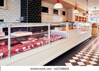 Variety of raw fresh veal meat in the refrigerated display of a butcher shop 