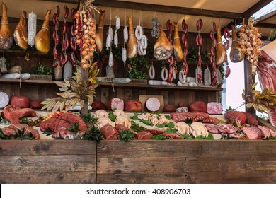 Variety of Raw Meat and sausages in Butcher Shop on Wooden Board