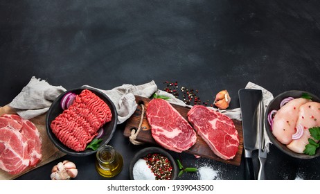 Variety of raw meat  with seasoning  on dark background. Top view with copy space