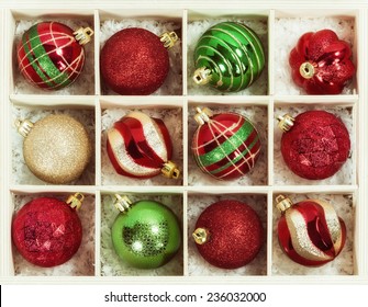 Variety Of Red, Green, And Golden Christmas Ball Ornaments In A Wooden Box 