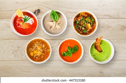 Variety Of Restaurant Hot Dishes, Healthy Food. Japanese Miso Soup, Asian Fish Soup, Russian Borscht, English Pea Soup, Mushroom Soup, Spanish Gazpacho On Wood. Top View, Flat Lay.