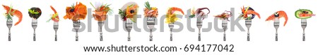 Variety of seafood appetizers on forks - white background