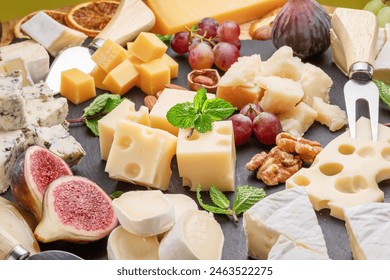 Variety of sliced cheeses with fruits, mint, nuts and cheese cutting knives. Wonderful cheese background for your projects. - Powered by Shutterstock