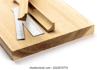 A Variety Of Strips Of Finishing Nails Or Brads In Various Lengths And Pieces Of Wood Trim Molding Isolated On White