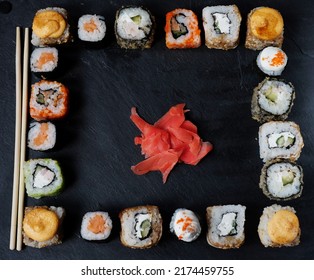 A Variety Of Sushi With Wooden Desk On Black Slate Background. Asian Food Frame. Dinner Party.Top View. Copy Space, Overhead, Flat Lay