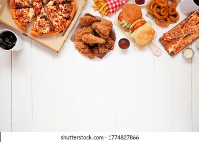 Variety of take out and fast foods. Pizza, fried chicken, hamburgers and sides. Top border. Overhead view on a white wood background with copy space. - Shutterstock ID 1774827866