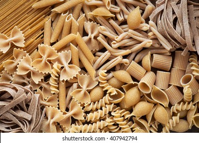 Variety of types and shapes of dry wholemeal pasta