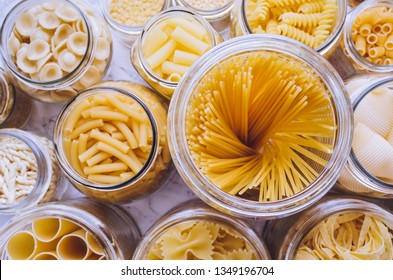 Variety of types and shapes of Italian pasta in glass jars on marble background. Italian cuisine food storage concept. Top view. Copy space. - Powered by Shutterstock