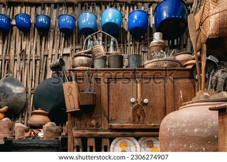 Variety and types of utensils for simple cooking of Asian families in the past. Traditional Asia and Thai old kitchen style interior. Antique kitchen with utensils at bamboo cottage. Selective focus.