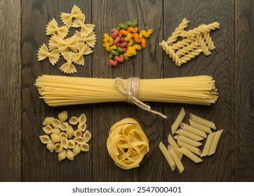 A variety of uncooked pasta types including spaghetti, shells, farfalle, fusilli, tagliatelle, and colorful spirals neatly arranged on a rustic wooden surface - Powered by Shutterstock